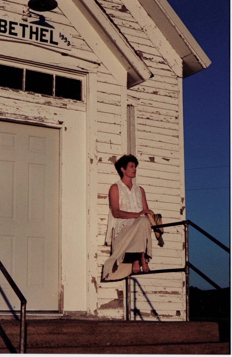 Regina Ochoa sitting outside Bethel Church, Whitney Nebraska